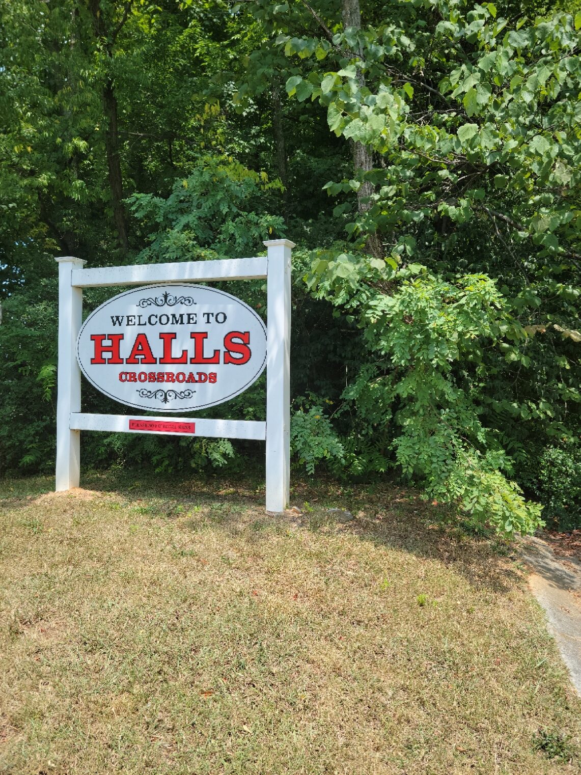 White and Red Welcome to Halls Crossroads sign.