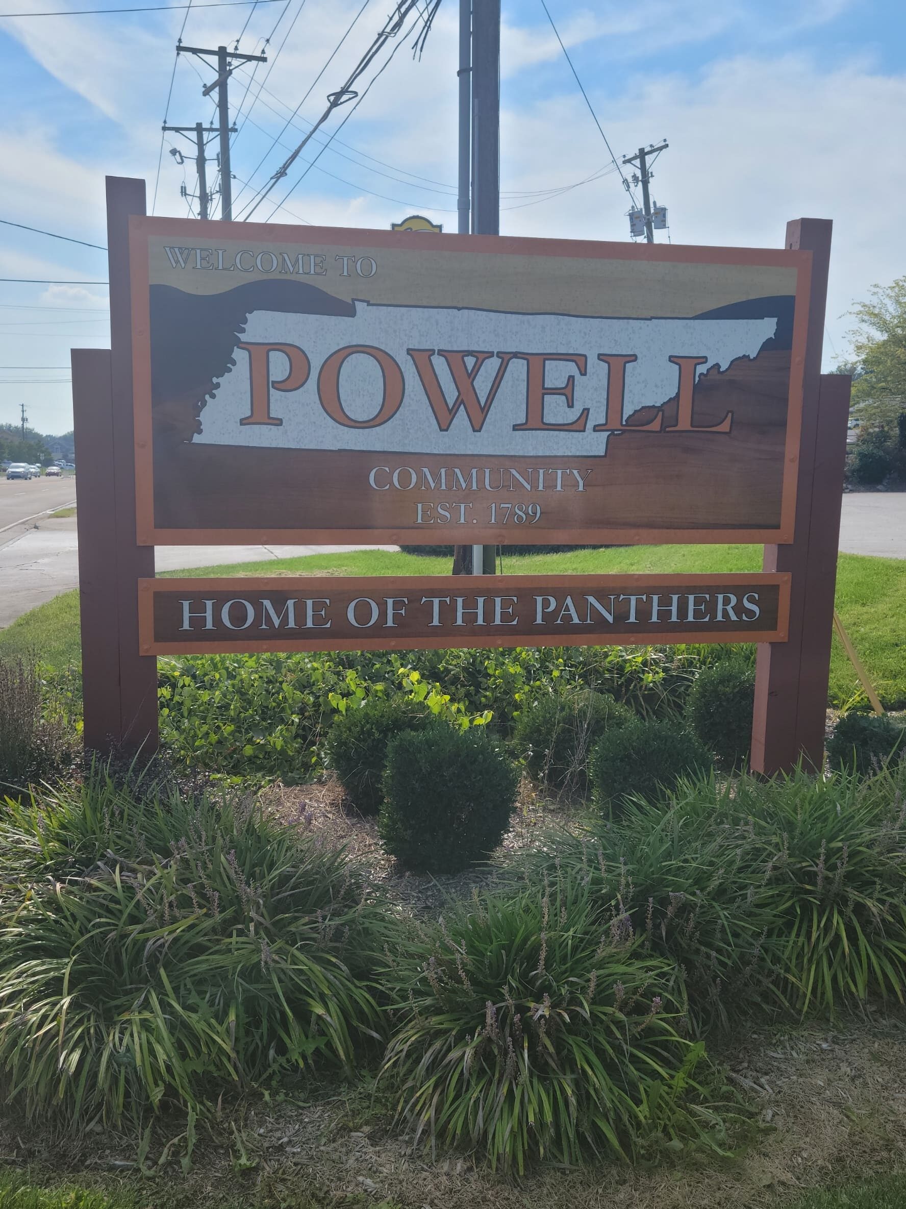 Orange and Brown Welcome to Powell Community sign.